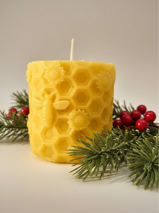 Beeswax candle with a bee on a honeycomb motif